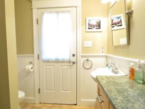 a bathroom with a white door and a sink at Cedar Cottage in Cape May Point +20 photos