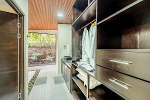 a bathroom with wooden cabinets and a walk in shower at Mountain Whisper in Tilarán +6 photos