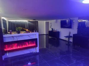 a living room with a fireplace with red flames at Suite Privée Deluxe O'Palawan Gold PROCHE TOURCOING CENTRE in Tourcoing