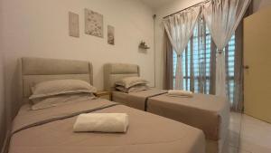 two beds in a room with a window at Zahran Homestay in Papar