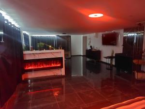 a living room with a fire place in the middle at Suite Privée Deluxe O'Palawan Gold PROCHE TOURCOING CENTRE in Tourcoing +7 photos
