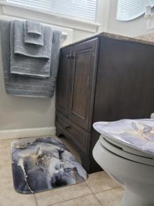 a bathroom with a toilet and a sink and towels at Everything Bigger in texas in Houston