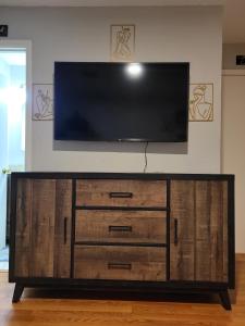 a flat screen tv on top of a wooden entertainment center at Everything Bigger in texas in Houston +35 photos