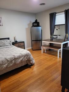 a bedroom with a bed and a desk and a refrigerator at Everything Bigger in texas in Houston