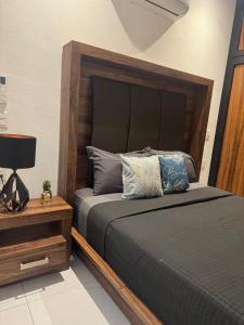 a bedroom with a bed with a wooden headboard at Orion 2nd Floor in Tepic
