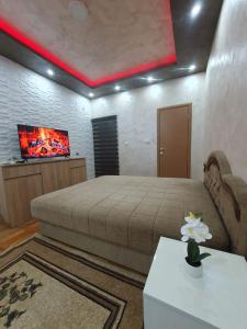 a bedroom with a bed and a flat screen tv at Trend Lux Obrenovac, sa parkingom in Obrenovac