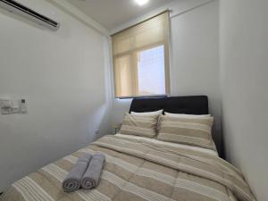 a bed in a white room with a window at MySky Putrajaya in Putrajaya