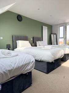 two beds in a room with green walls at The Alcove Retreat in Bristol