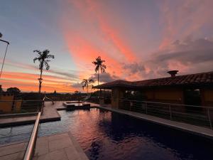 a sunset over a pool at a house with a sky at Ecohotel Guaduales Nature in Pereira