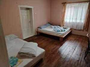 two beds in a room with wooden floors and a window at Casa Rei in Vidolm