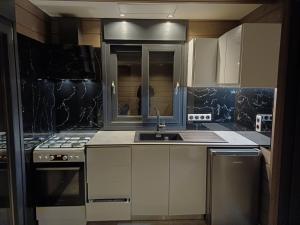 a kitchen with white cabinets and a sink at Schinias beach villa 1 in Schinias