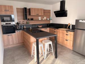 a kitchen with a black counter and a refrigerator at Chez sana in Saint-Dizier