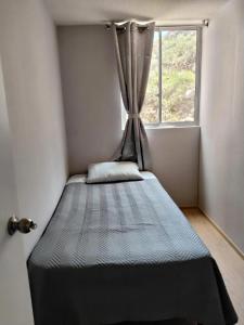 a bed in a small room with a window at Cusi Wasi AQP in Arequipa