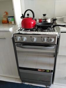 a red tea kettle on top of a stove in a kitchen at Cusi Wasi AQP in Arequipa