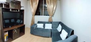 a living room with a blue couch and a tv at Cusi Wasi AQP in Arequipa