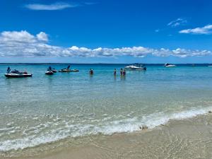 a group of people in the water at the beach at Turtle Cove Lake Front Cabin 300m To Beach in Hervey Bay
