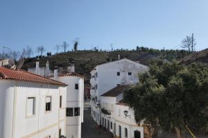 a group of buildings in a town with a hill at Casas Luar da Aldeia - Apartamentos in Odeceixe