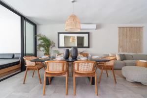 a dining room with a table and chairs and a couch at Casa Kaybe in Tulum