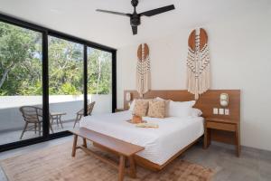 a bedroom with a bed and a table and windows at Casa Kaybe in Tulum +76 photos