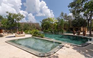 a swimming pool in the middle of a resort at Casa Kaybe in Tulum