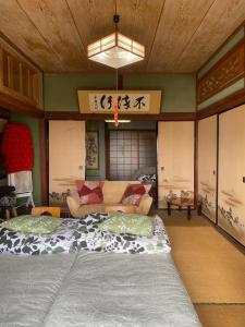 a room with two beds and a couch in it at Inn Omishima in Imabari