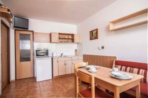a small kitchen with a wooden table and a dining room at Studio with Pool in Benecko-Riesengebirge 2218 in Benecko