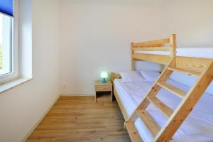 a bedroom with a bunk bed with a ladder at Comfortable holiday homes with a summer pool in Jarosławiec +22 photos
