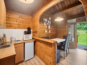 a kitchen with wooden walls and a table and chairs at Finnische Blockhausstilhäuser im Harz in Benneckenstein +31 photos
