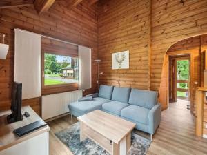 a living room with a blue couch and a table at Finnische Blockhausstilhäuser im Harz in Benneckenstein