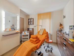 a hospital room with a bed with an orange blanket at Finnische Blockhausstilhäuser im Harz in Benneckenstein