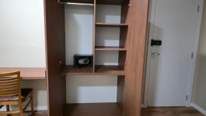 a closet with a wooden book shelf with a clock on it at Pousada Trapiche in Pelotas