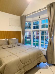 a bedroom with a bed and a large window at BeInn - Short Stay Collection Penedo in Itatiaia