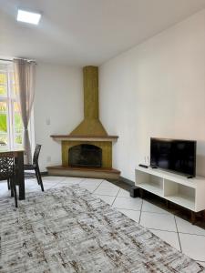 a living room with a fireplace and a tv at BeInn - Short Stay Collection Penedo in Itatiaia