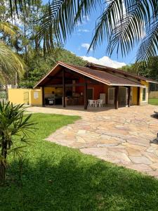 a house with a patio and a yard at BeInn - Short Stay Collection Penedo in Itatiaia