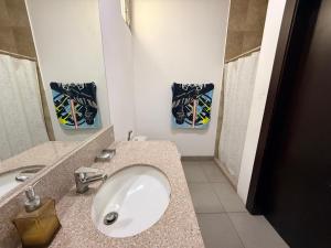 a bathroom with a white sink and a mirror at Habitación en el Tornero in SamborondÃ³n
