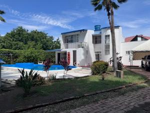 a large white house with a swimming pool at Ricaurte casa campestre in Ricaurte