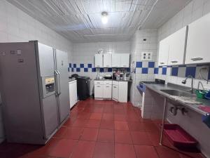 a kitchen with a red tile floor and a refrigerator at Ricaurte casa campestre in Ricaurte