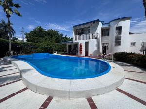 a swimming pool in front of a house at Ricaurte casa campestre in Ricaurte