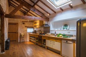 uma grande cozinha com pisos em madeira e uma clarabóia em Clos Sandrine Gindou Lot em Gindou