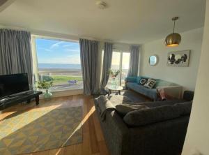 a living room with a couch and a large window at Central location Sea view in Hastings