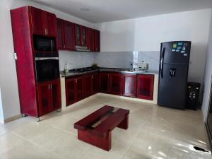 a kitchen with red cabinets and a black refrigerator at Casa Aranza in Cartagena de Indias