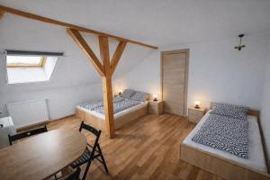 a room with two beds and a table and a dining room at HannaBella Vendégház & Wellness in Miskolc