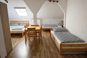 a room with three beds and a table and chairs at HannaBella Vendégház & Wellness in Miskolc