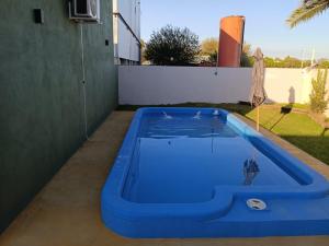 a blue swimming pool in the backyard of a house at Palmeras al sol in San Pedro