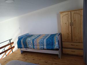 a bedroom with a bed and a wooden cabinet at Palmeras al sol in San Pedro