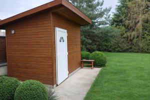 a wooden shed with a bench in a yard at HannaBella Vendégház & Wellness in Miskolc