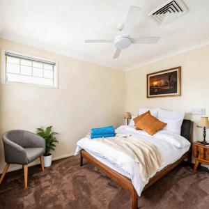 a bedroom with a bed and a ceiling fan at Stunning Absolute Waterfront With Private Jetty in Fishing Point +35 photos