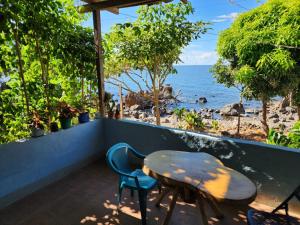 a table and chairs on a balcony overlooking the ocean at Calala House in Balgue
