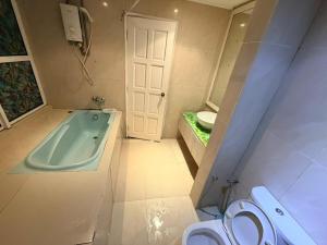 a bathroom with a bath tub and a toilet at Klcc Cozy Unit in Kuala Lumpur +13 photos