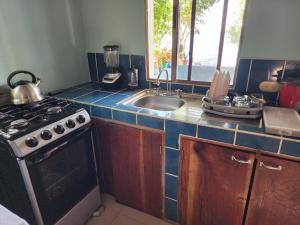 a kitchen with a stove and a sink at Calala House in Balgue